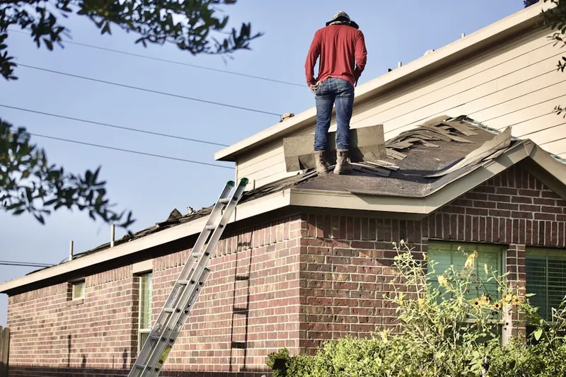 Professional roofer working on a residential roof in Reed